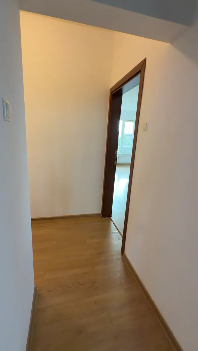 Hallway with light-colored walls and wood-look flooring